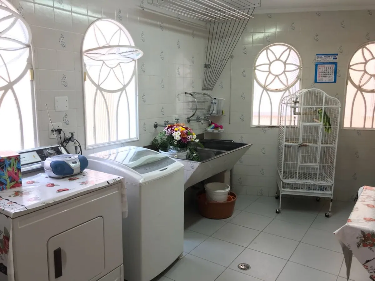 Área de serviço com tanque inox, máquina de lavar, janelas arqueadas vazadas e gaiola, antes da reforma