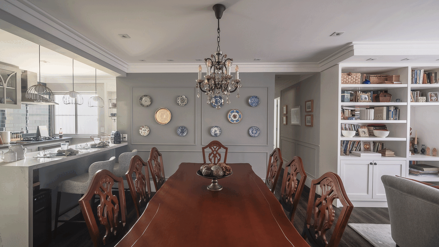 Sala de jantar com mesa de madeira maciça, cadeiras de assento azul, aparador antigo e parede de pratos azuis